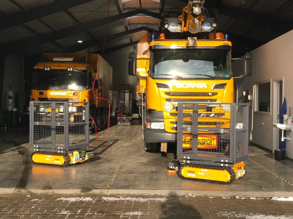 First-Mover tracked carriers with mesh cages beside Scania særtransport trucks